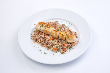 chicken kebab with buckwheat on the white plate