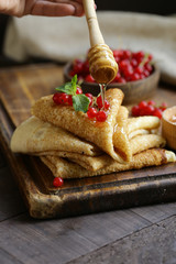 thin pancakes with berries and honey