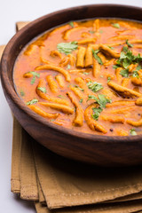 Dhaba style Sev bhaji/sabzi/curry made in tomato curry with gathiya shev, served in a bowl or karahi, selective focus
