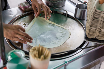 Roti Making, roti thresh flour by roti maker with oil. Indian traditional street food. Thai Pancake Banana And Egg . Thai Street Food and Desserts. Making of roti snack