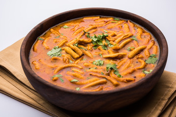 Dhaba style Sev bhaji/sabzi/curry made in tomato curry with gathiya shev, served in a bowl or karahi, selective focus