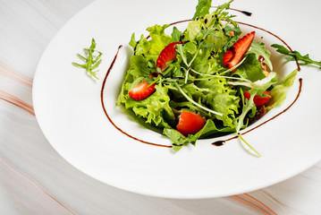 healthy salad with strawberriesa and arugula