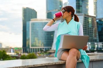 Fototapeta premium Portrait of business woman sitting with laptop and cup of coffee