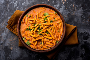Dhaba style Sev bhaji/sabzi/curry made in tomato curry with gathiya shev, served in a bowl or...