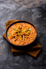 Dhaba style Sev bhaji/sabzi/curry made in tomato curry with gathiya shev, served in a bowl or karahi, selective focus