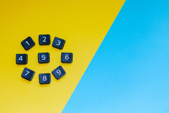 On the yellow-blue background are black cards with numbers. Mathematical and arithmetic concept.
