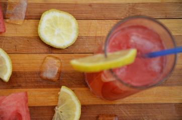 Colorful tropical fresh watermelon smoothie summer drinks in the glasses on wood table background. Refreshing watermelon coсtail with slimon of green foliage. The concept of leisure, travel