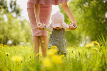 Mother and daughter on a meadow with dandelions