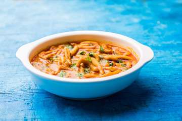 Dhaba style Sev bhaji/sabzi/curry made in tomato curry with gathiya shev, served in a bowl or karahi, selective focus