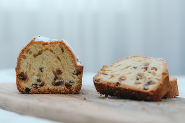Raisin cake, dusted with icing sugar. Cupcake with raisins on a wooden board.