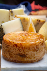 Variety of Italian pecorino and provolone cheeses, yellow aged, with black peppers from Nebrodi, white Il Palio and black molarotto, close up