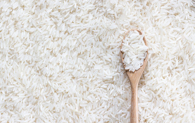 Top view of white rice and wooden spoon