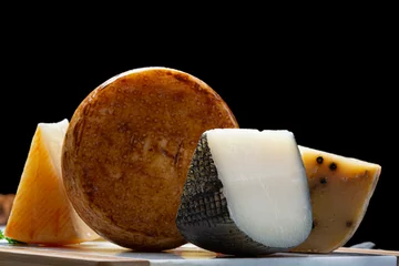 Fotobehang Variety of Italian pecorino cheeses, yellow aged, with black peppers from Nebrodi, white Il Palio and black molarotto, close up © barmalini
