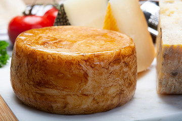 Variety of Italian pecorino cheeses, yellow aged, with black peppers from Nebrodi, white Il Palio and black molarotto, close up