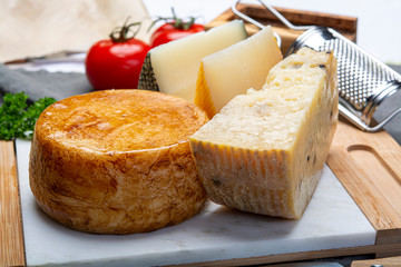 Variety of Italian pecorino cheeses, yellow aged, with black peppers from Nebrodi, white Il Palio and black molarotto, close up