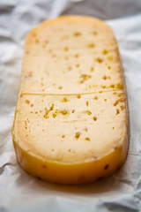 Piece of cow cheese with fenugreek seeds made in Belgian abbey by monks.