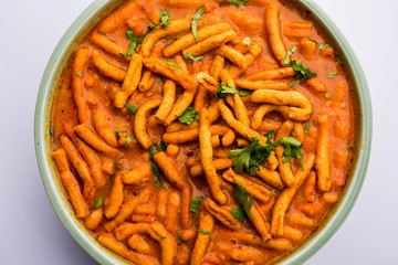 Dhaba style Sev bhaji/sabzi/curry made in tomato curry with gathiya shev, served in a bowl or karahi, selective focus