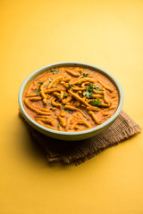 Dhaba style Sev bhaji/sabzi/curry made in tomato curry with gathiya shev, served in a bowl or karahi, selective focus