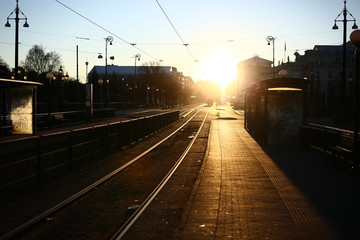 Naklejka na ściany i meble Early winter morning on a tram stop with strong sunlight on the Avenue, Gothenburg, Sweden