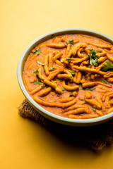 Dhaba style Sev bhaji/sabzi/curry made in tomato curry with gathiya shev, served in a bowl or karahi, selective focus