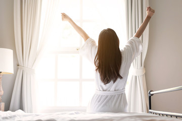 asian woman relaxing in the hotel room, strectching out, copy space