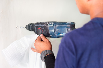 Man doing drilling holes on the wall