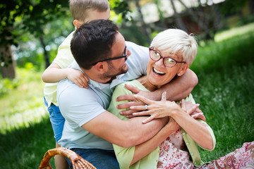 Fototapeta premium Happy family playing and enjoying picnic with children outside