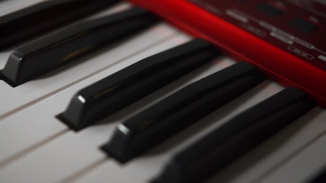 Passion for music, electric piano keyboard keys reveal, close tilt up shot