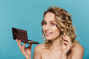 Image of caucasian half-naked woman applying makeup with cosmetic pallet and brush isolated