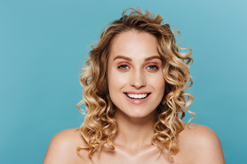 Beauty image of charming half-naked woman with curly hair smiling and looking at camera