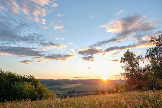 Beautiful sunset on a hill among the trees overlooking the village © Eduard Vladimirovich