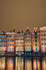 Brick houses and canal in amsterdam at night - obrazy, fototapety, plakaty