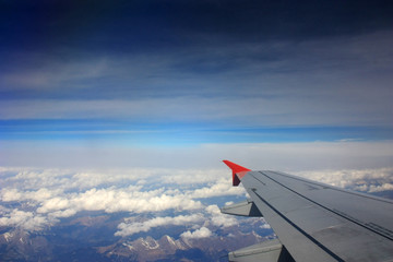 Obraz premium Airplane wing in the blue sky