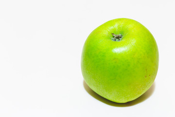 Juicy green apple with smooth and shiny peel on white background – Nutritious fruit with low calories good in diets with copy space – Sweet healthy snack full of vitamins