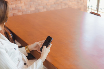 Woman Hand using smartphone in coffee shop,office