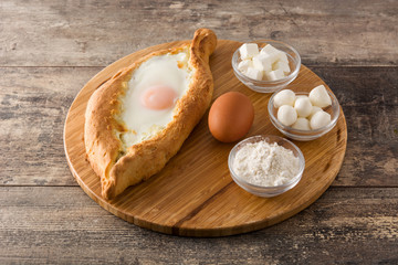 Traditional Adjarian Georgian khachapuri with cheese and egg on wooden table