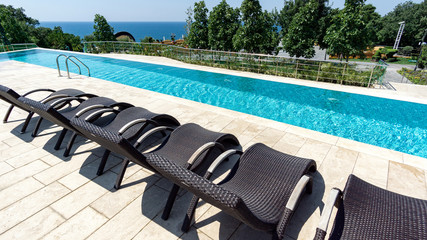 a number of sun beds at the outdoor swimming pool, blue water channel