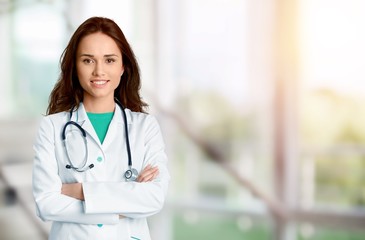 Young beautiful nurse on blurred hospital background