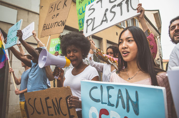 Public demonstration on the street against global warming and pollution. Group of multiethnic people making protest about climate change and plastic problems in the oceans - obrazy, fototapety, plakaty