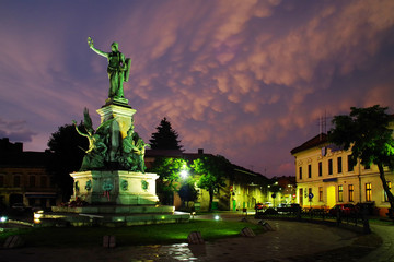 Fototapeta na wymiar Stormy clouds over the monument and buildings of the Reconciliation Park of Arad, Romania, Europe
