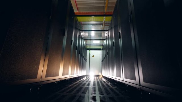 Racks with modern computers stand in rows in a server room.
