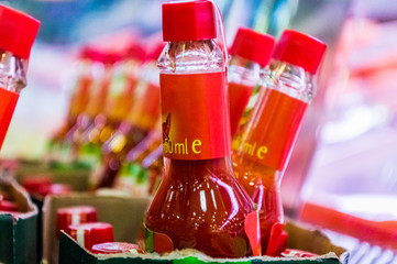 Closeup view of several glass bottles filled with red hot sauces