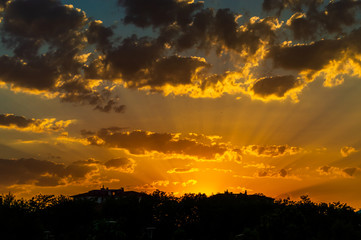 Fototapeta na wymiar Cloudy sunset view with city silhouette