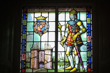 Obraz na płótnie Canvas A colorful glass window in memory of John Gaunt, Duke of Lancaster with the effigy of the city and his castle. British Medieval art. Northwest England. UK.