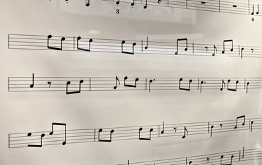 Black musical notes on white background, in perspective view.