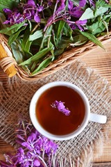 Traditional Russian herbal drink. Ivan-tea in a Cup close-up on a wooden table. It has a positive effect on the human body.