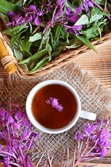 Traditional Russian herbal drink. Ivan-tea in a Cup close-up on a wooden table. It has a positive effect on the human body.