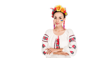 brunette young woman in national Ukrainian embroidered shirt and floral wreath with crossed arms...