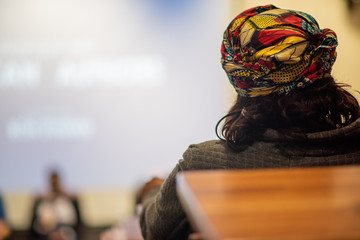 Woman with headscarf sitting in class listening to lecturer