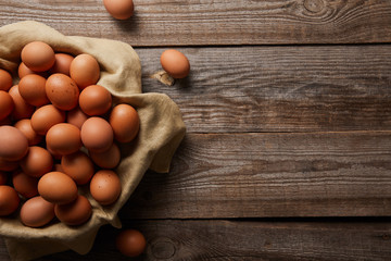 top view of chicken eggs at cloth on wooden table